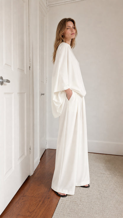 Model posing in white lounge set showing side profile