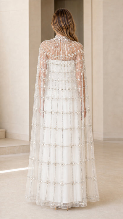 Back view of model wearing Ivory White sheer beaded cape formal gown