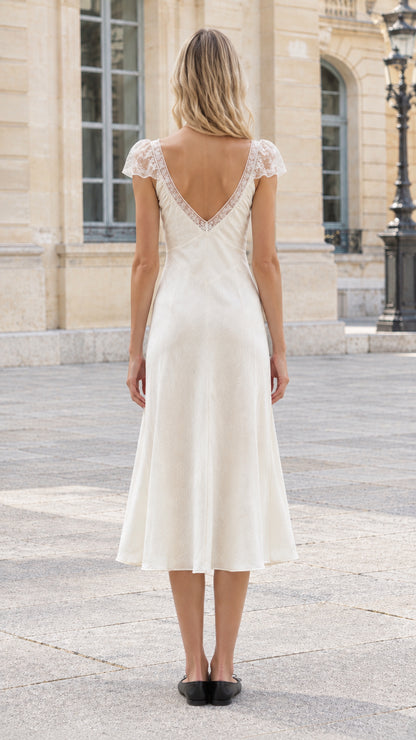 Back view of ivory satin dress showing deep V-back with lace trim