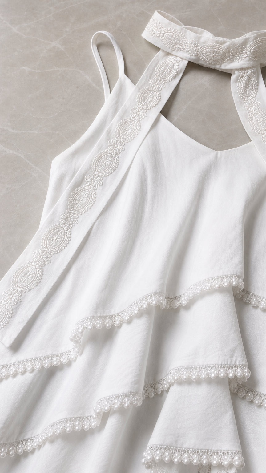 Close-up detail of white camisole ruffles and neckline scarf