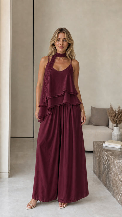 Model wearing burgundy layered camisole and wide-leg pants set