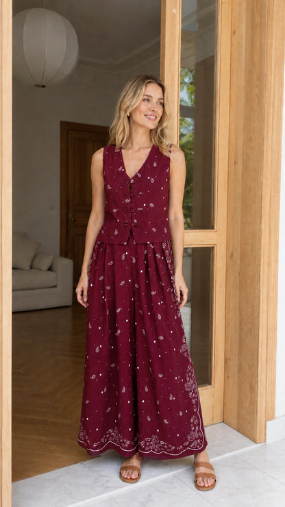 Model wearing burgundy printed vest and wide-leg pants set