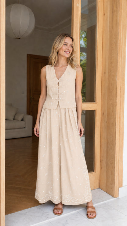 Model wearing beige printed vest and wide-leg pants set
